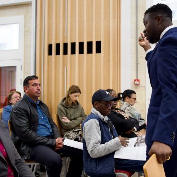 Photo from YMCA Homeinclusration study launch of a speaker presenting amongst the crowd.