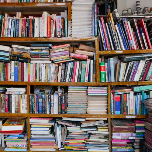 This is an image of inside the YMCA Charity & Vintage Shop. It shows many books across some shelves.