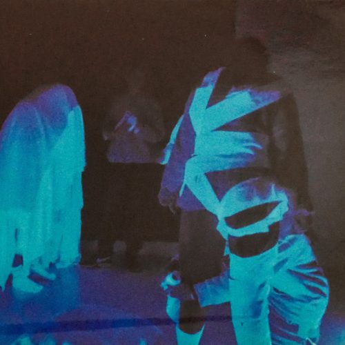 Performance artists under UV lights during Ten Sing.